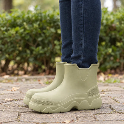 Gummistiefel Damen kurz in Salbeigrün getragen auf nassem Pflaster