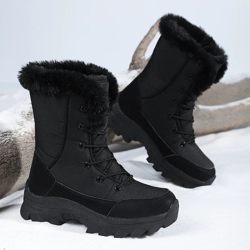 Winterstiefel Damen in Schwarz – Paar in Dreiviertelansicht im Schnee