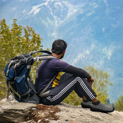 Sockenschuhe Sturmgrau beim Wandern auf einem Felsen getragen