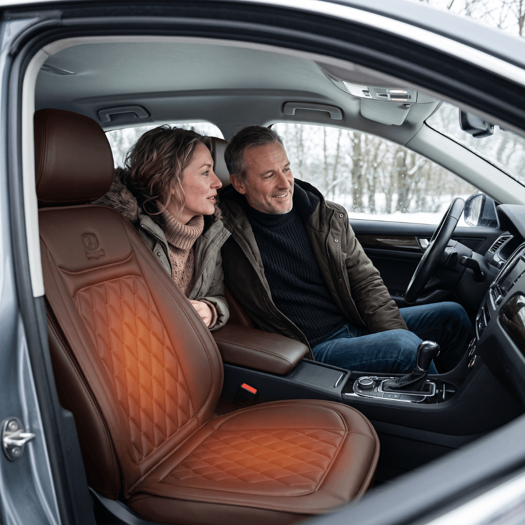 Paar im Auto mit beheizbarer Sitzauflage in Braun