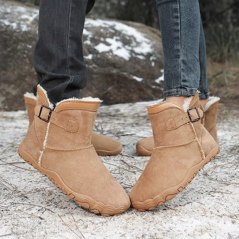 Winter Barfußschuhe in Kastanienbraun getragen auf verschneitem Waldboden