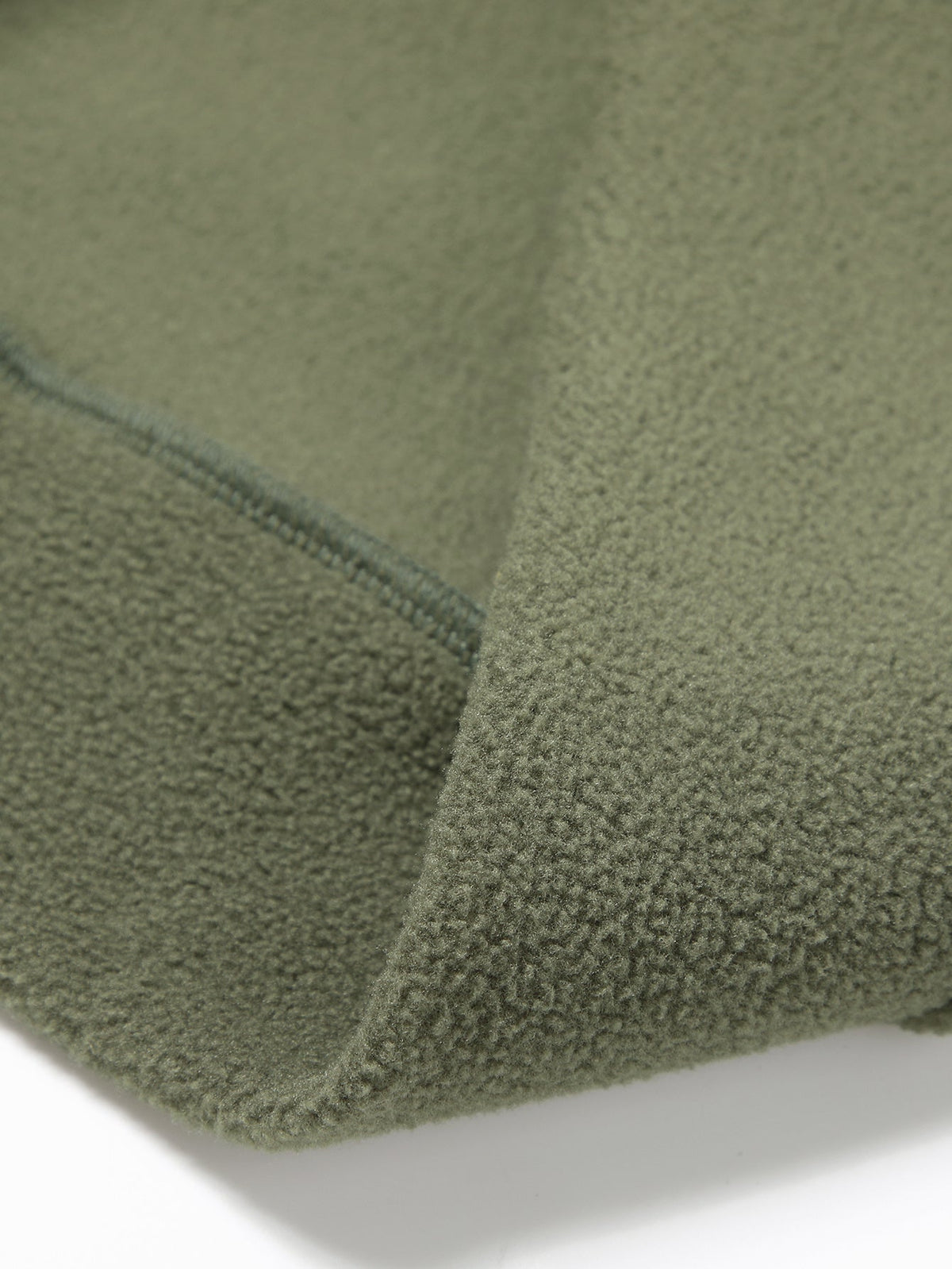 Nahaufnahme des angerauten Fleece-Materials in Olivgrün mit versäuberter Naht