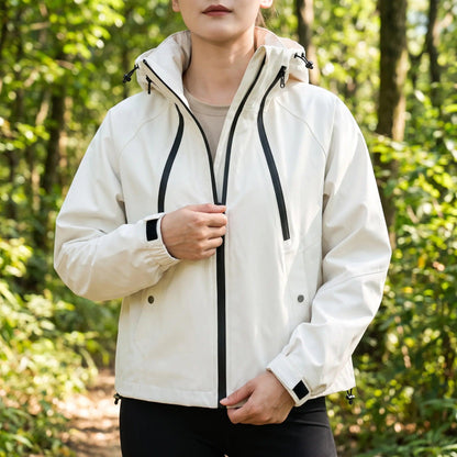 Frau in der weißen 3-in-1 Wanderjacke auf einem Waldweg