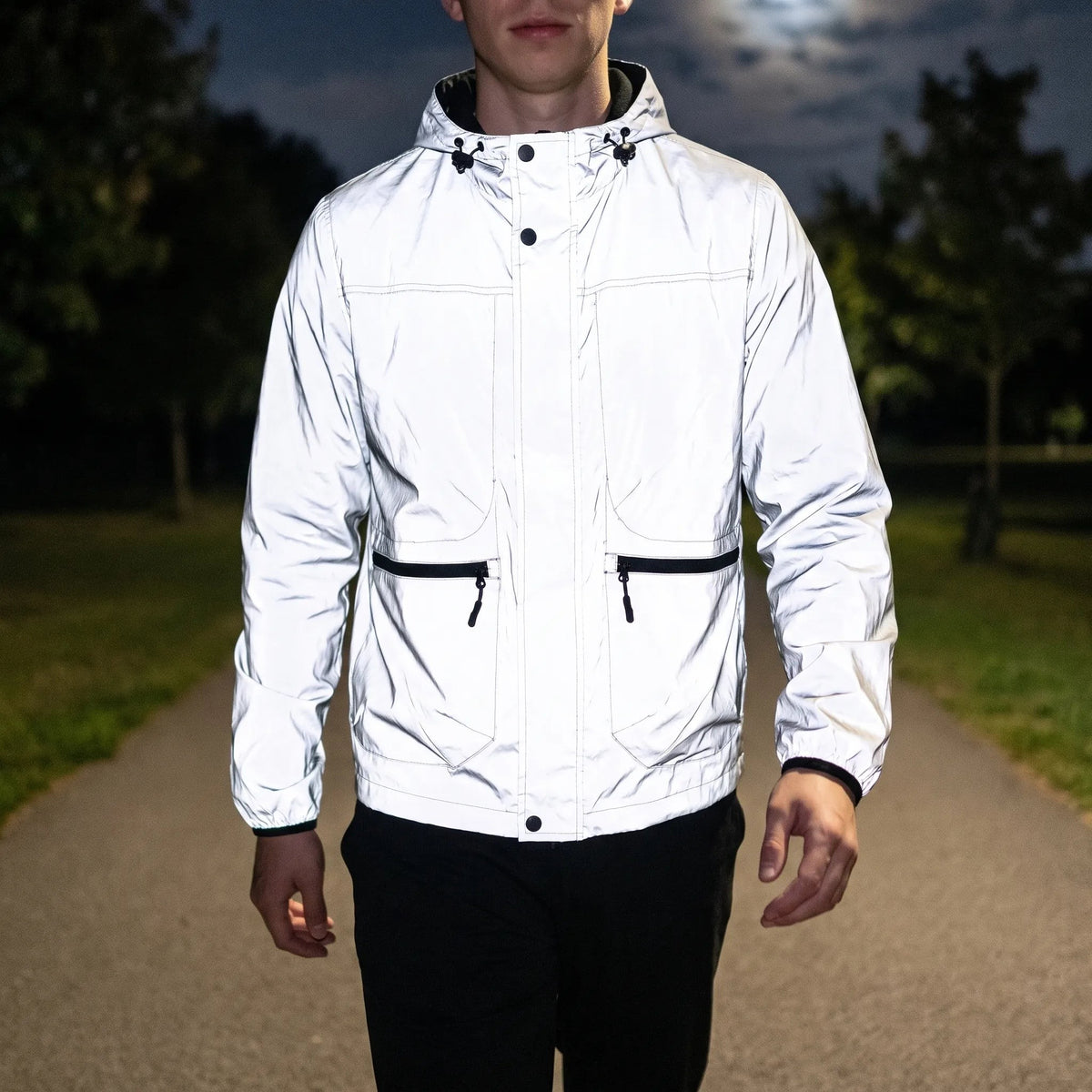 Vollflächig reflektierende Jacke Herren leuchtet nachts im Scheinwerferlicht auf dem Radweg
