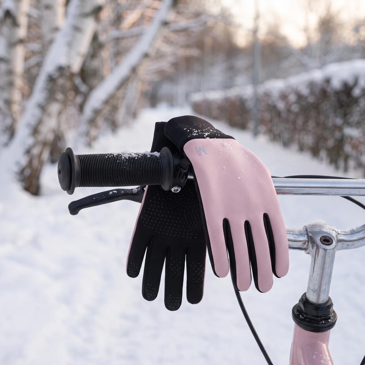 Kinderhandschuhe mit Silikongriff auf dem Lenker eines Kinderfahrrads im Schnee