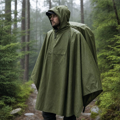 Olivgrüner Regenponcho mit Kapuze im Regen auf einem Waldweg