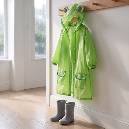 Grüner Kinder-Regenmantel mit Froschkapuze hängt an einer Garderobe neben Gummistiefeln