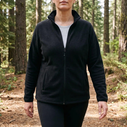 Frau in der schwarzen Fleecejacke auf einem Waldweg