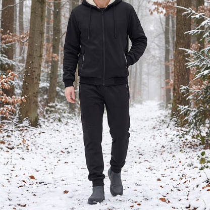 Jogginganzug Herren in Schwarz, getragen beim Spaziergang im verschneiten Wald