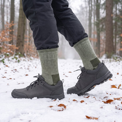 Thermosocken mit 50 % Wolle an den Waden beim Spaziergang auf verschneitem Waldweg