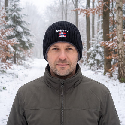 Wintermütze Herren in Schwarz mit NORWAY-Stickerei, getragen im verschneiten Mischwald
