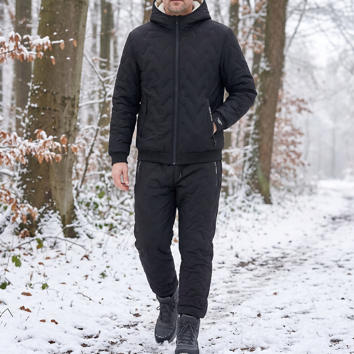 Thermoanzug Herren in Schwarz, getragen beim Spaziergang im verschneiten Wald