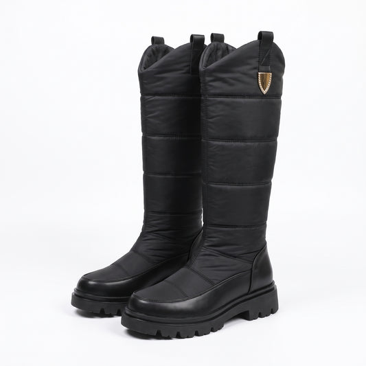 Schneestiefel Damen Schwarz, hoher Steppschaft mit Zierclip und Profilsohle, auf weißem Hintergrund