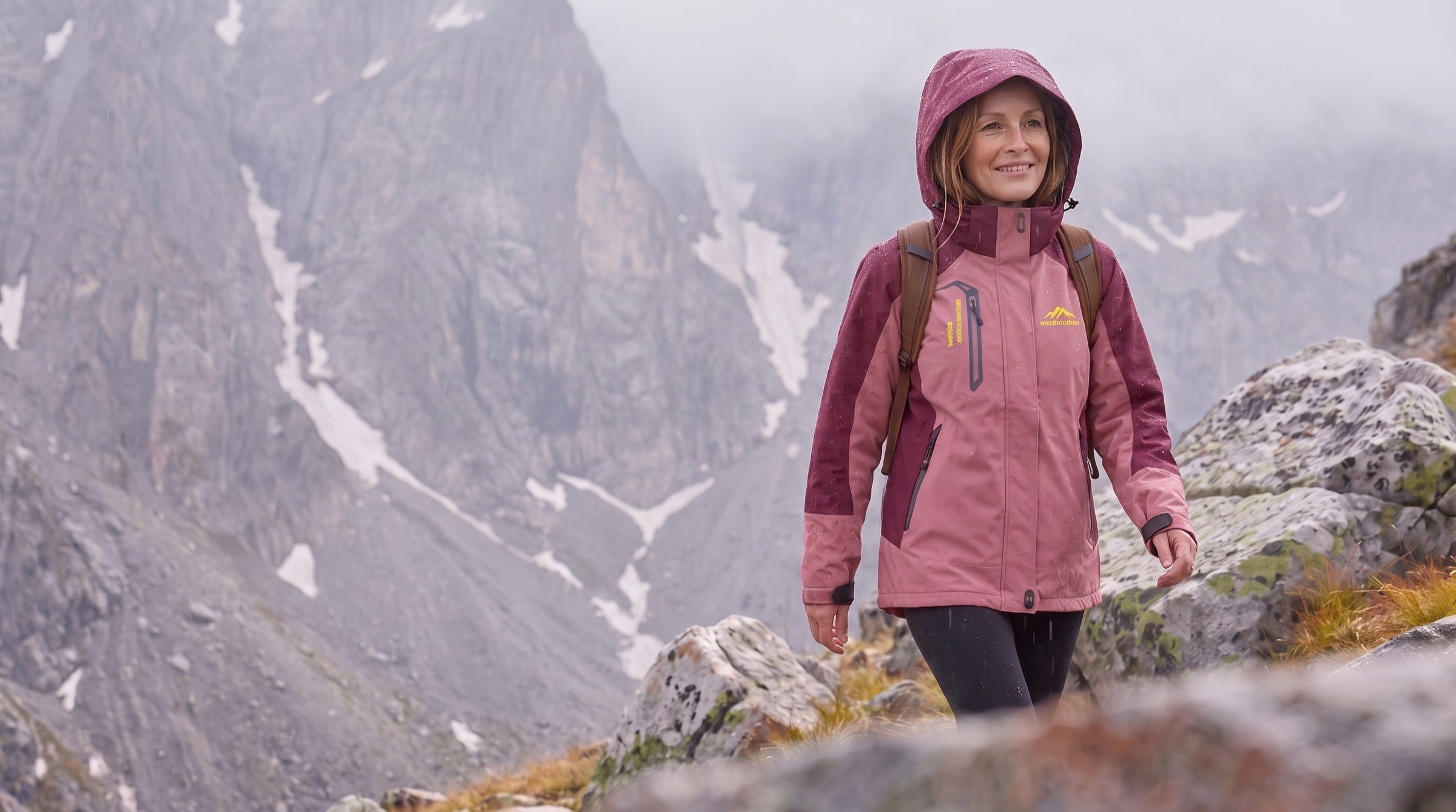 Wanderin in wasserdichter Jacke im Regen auf einem Bergpfad